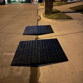 Two modular driveway ramps installed at night to improve curb access for vehicles.