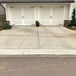 Two-section driveway curb ramps placed in front of a double garage, designed to provide smooth access and prevent vehicle scraping.