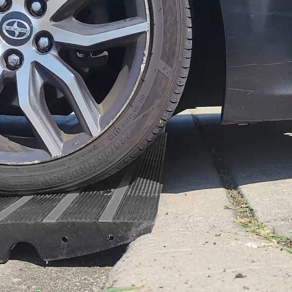 Close-up of car tire on CurbMaster Pro ramp for driveway lip clearance and curb protection