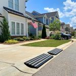 Driveway ramp with reflector installed in front of a residential home, designed to prevent car scraping and provide safe curb access.