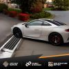 Low-profile sports car using an angled curb clearance ramp for a smooth driveway transition.