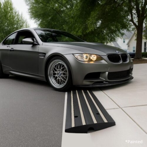 Low-profile BMW using a rubber driveway curb ramp for smooth garage entry and scrape prevention