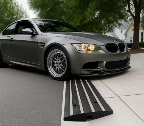 Low-profile BMW using a rubber driveway curb ramp for smooth garage entry and scrape prevention
