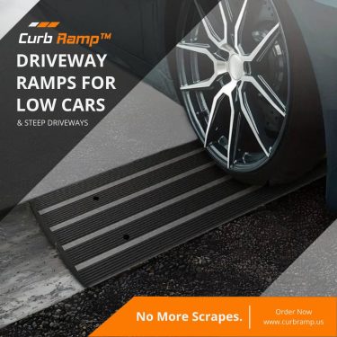 A low car wheel using a black driveway ramp to navigate a steep driveway, demonstrating the ramp’s effectiveness in preventing undercarriage scrapes.