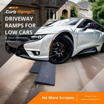 White sports car using black rubber driveway ramps for steep curb access