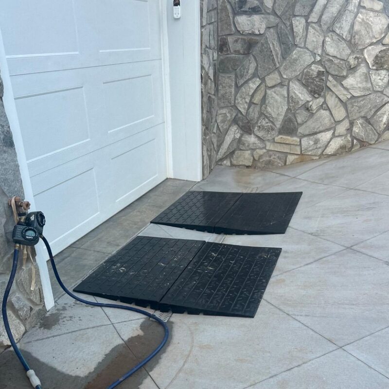 Garage threshold ramp for steep driveway lip and French drain transition preventing car scraping