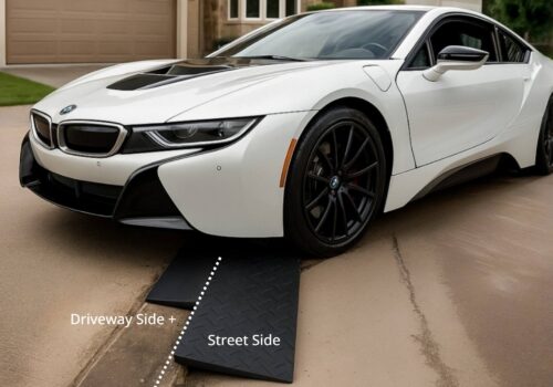 BMW i8 using a driveway-side and street-side ramp setup to cross a steep gutter lip without scraping the front bumper.