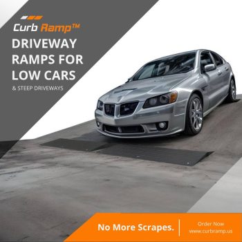 Low-clearance car using ramps to safely navigate a steep driveway and prevent scraping, ensuring a smooth transition over uneven surfaces.