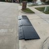 Modular ramp system installed on a steep driveway curb to improve vehicle clearance.