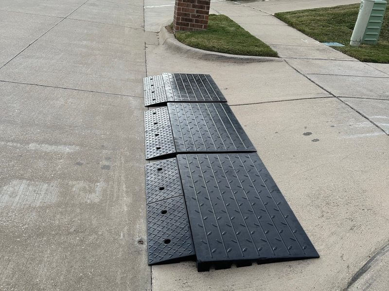 Modular ramp system installed on a steep driveway curb to improve vehicle clearance.