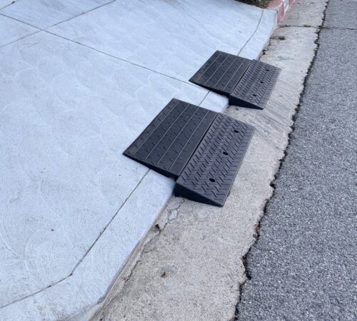 1.5-Inch Rolled Curb Driveway Ramps – Threshold Lip Clearance Setup Two 1.5-inch rubber ramps positioned on a rolled curb to smooth the driveway lip and help low cars cross without scraping.