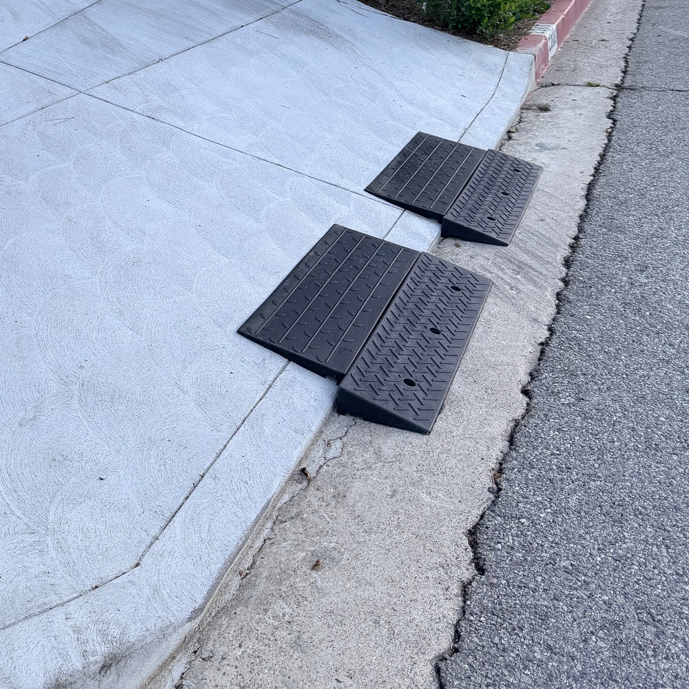 1.5-Inch Rolled Curb Driveway Ramps – Threshold Lip Clearance Setup Two 1.5-inch rubber ramps positioned on a rolled curb to smooth the driveway lip and help low cars cross without scraping.