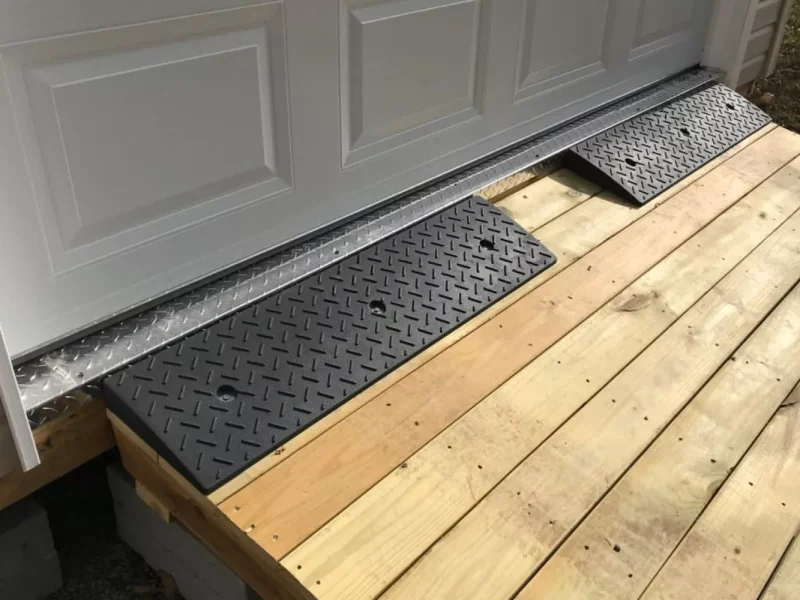 Heavy-duty threshold ramp installed at a garage door entry for smooth transitions for vehicles and equipment.