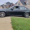 Low-profile black sedan on driveway curb ramp