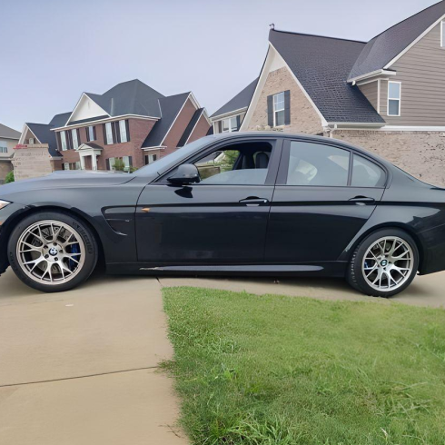 Low-profile black sedan on driveway curb ramp