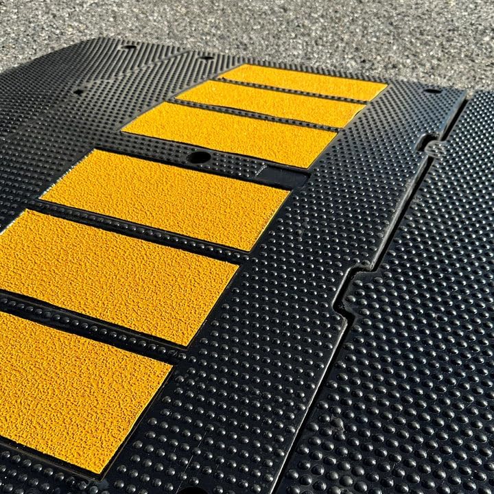 Heavy duty rubber driveway ramp closeup with textured anti slip surface and yellow traction strips