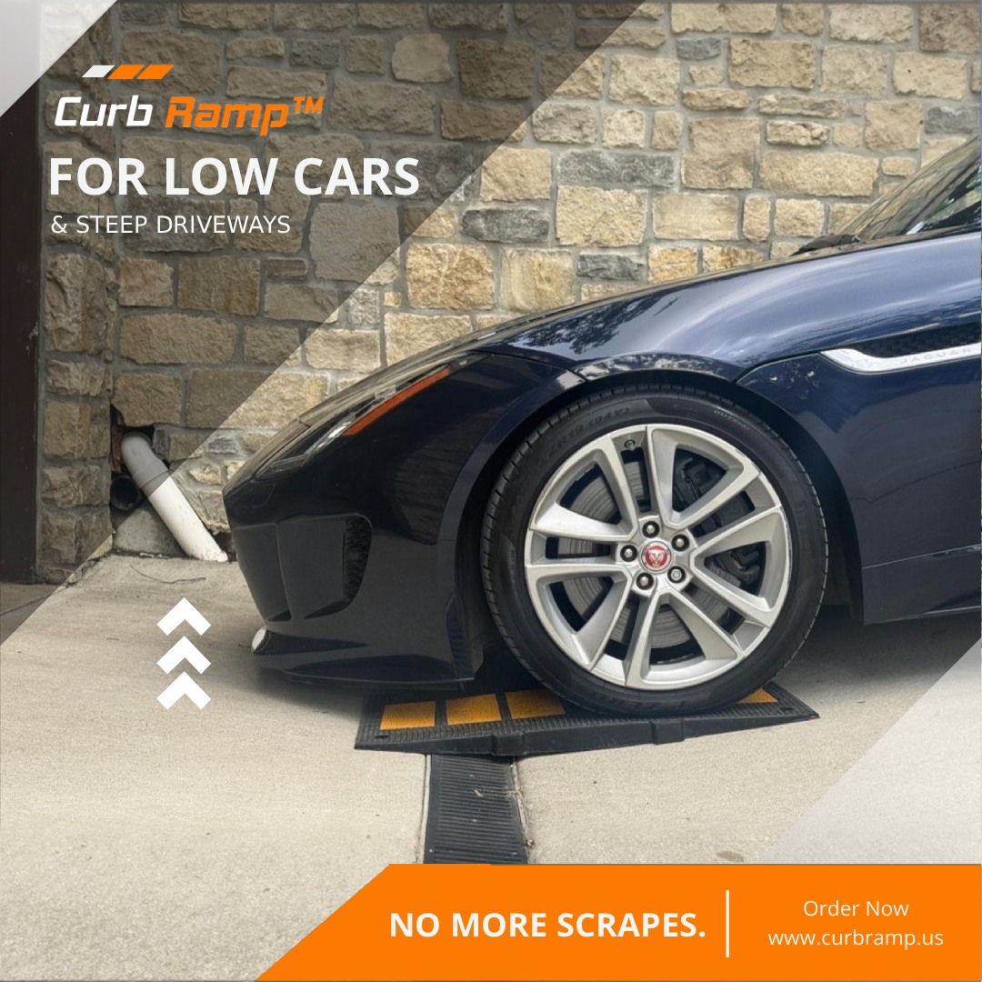 Low-clearance car rolling over a garage drain using a rubber driveway ramp to prevent front-end scraping on a steep driveway.