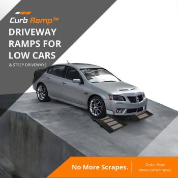 Low-clearance car using a ramp system to safely navigate a steep driveway drop-off, preventing scraping and ensuring smooth access.