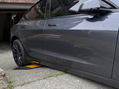 low-clearance-tesla-on-steep-driveway-using-curb-ramp-for-scrape-protection