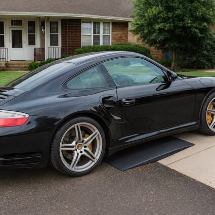 Low-clearance sports car using a portable driveway ramp to prevent front bumper scraping.