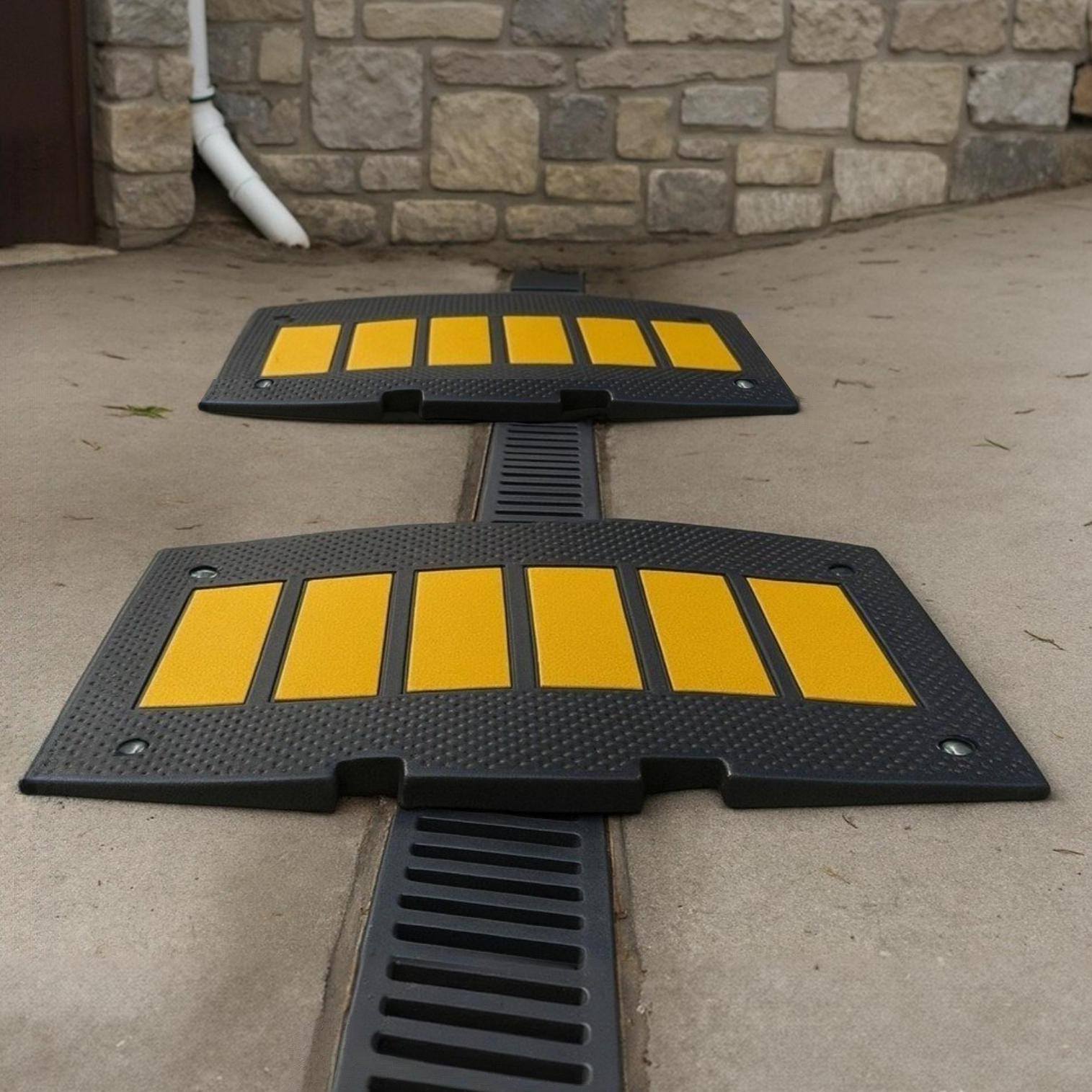 Driveway ramp over French drain for low car clearance and steep garage entry scraping prevention