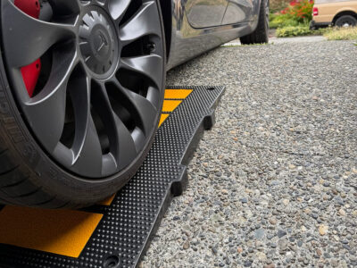 tesla-driving-over-curb-ramp-for-low-clearance-on-angled-driveway