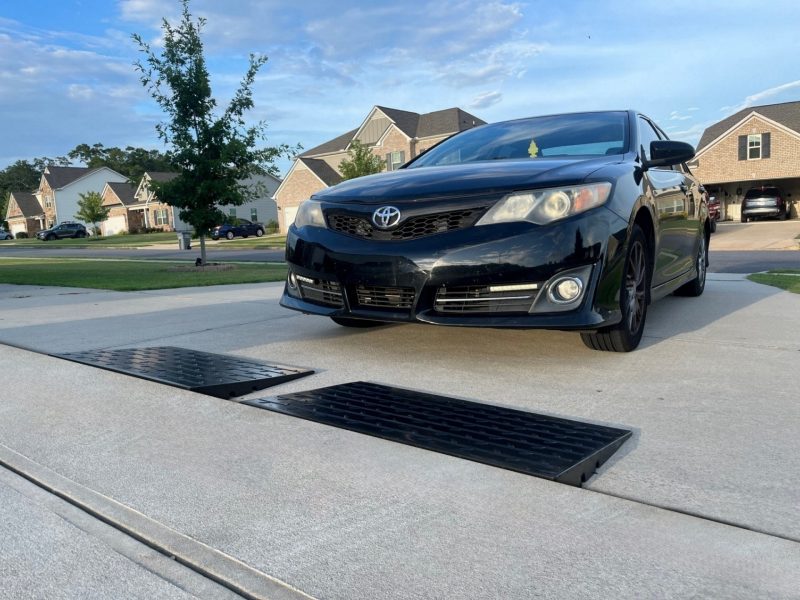 Black Toyota Camry parked on a driveway using threshold curb ramps for smooth garage entry.