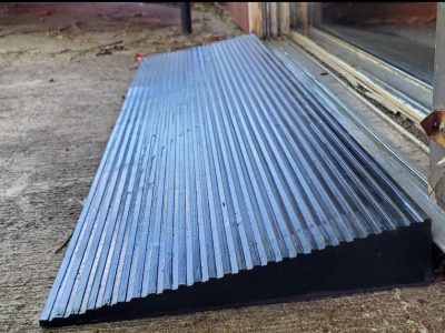 A high-density rubber ramp installed at a door threshold, providing a smooth transition for easier access.