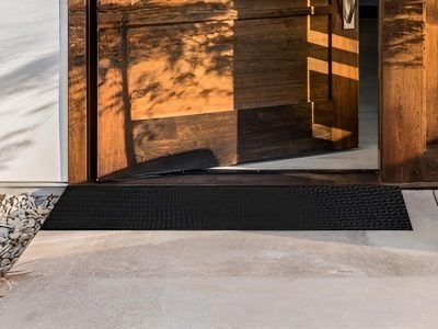 A rubber ramp positioned at the threshold of a front door, providing smooth and accessible entry into the home.