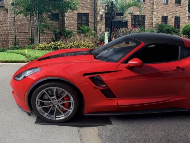 Red sports car using a Curb Ramp™ to easily access a steep driveway, preventing undercarriage scrapes and enhancing curb appeal.