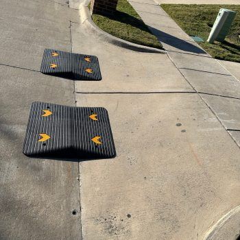 Two modular ramps installed on an angled driveway to facilitate smooth vehicle transitions.