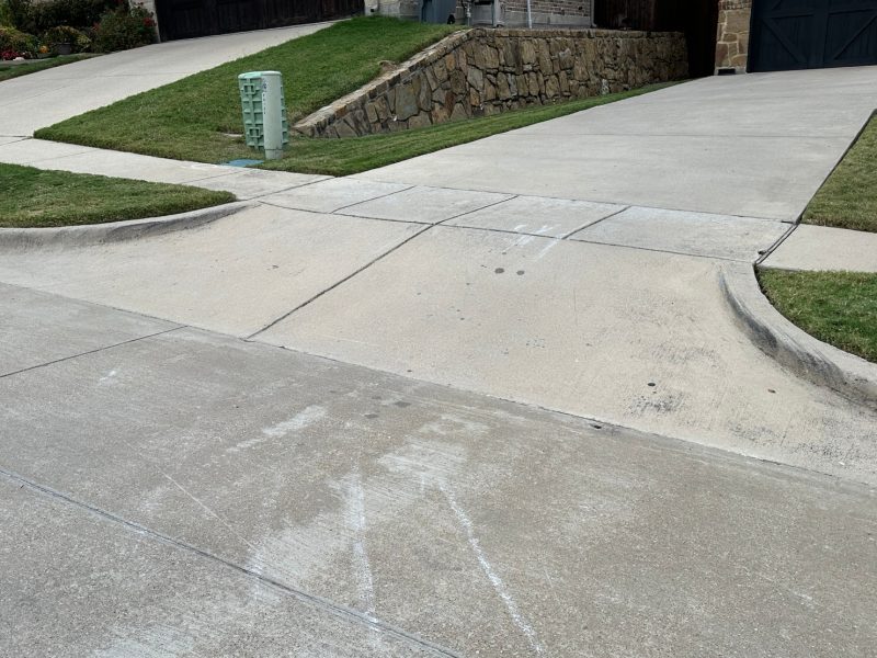 Steep driveway with a straight curb entry, showing the need for a driveway ramp to prevent scraping.