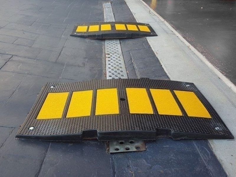 Heavy-duty garage entry ramp with yellow traction strips for steep driveways and low car clearance.