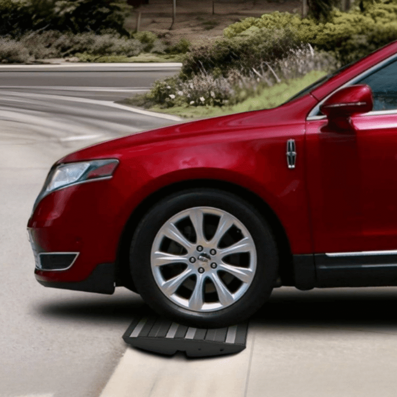 Low clearance vehicle smoothly driving over a steep driveway ramp, preventing damage and ensuring safe entry.