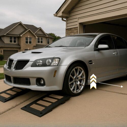 Low car using garage threshold ramps to prevent scraping on driveway drop-off