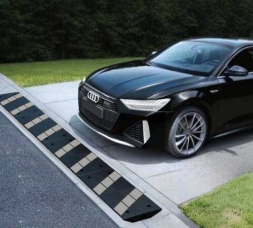 Low Audi driving over rolled curb driveway ramp to prevent front-end scraping