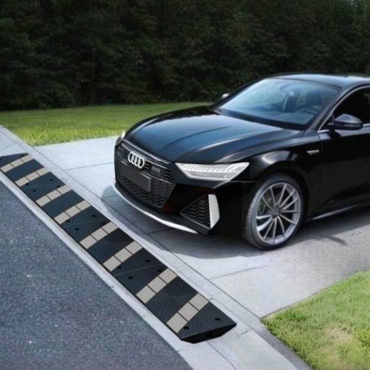 Low Audi driving over rolled curb driveway ramp to prevent front-end scraping