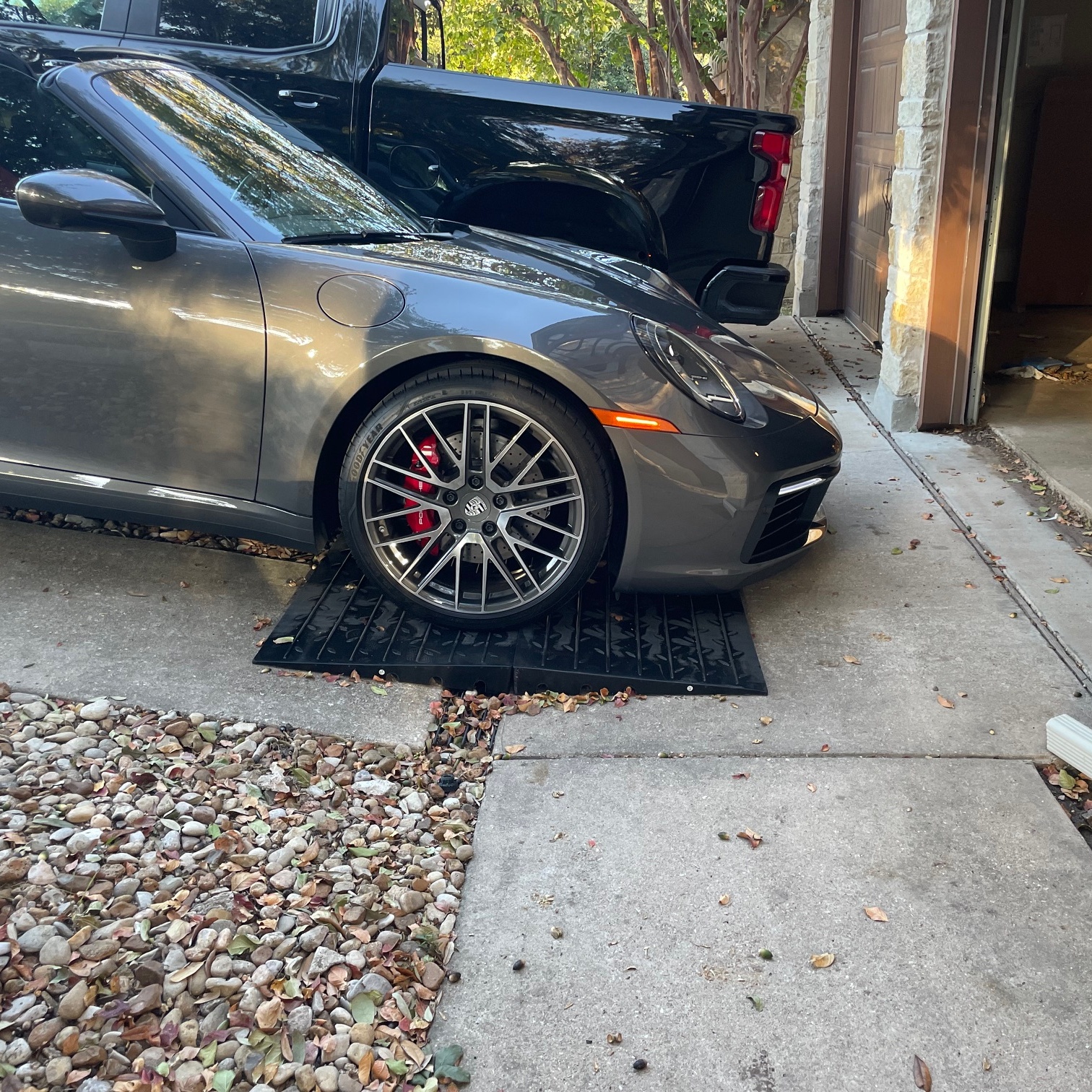 Front Lip Protection Ramp System for Steep Driveway Transitions Sports car using modular rubber ramp panels to prevent front-lip scraping on a steep driveway.