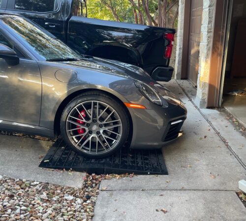 Front Lip Scrape Prevention Ramp System for Steep Driveway Transitions Low sports car using modular rubber ramps to prevent front lip scraping on a steep driveway transition.