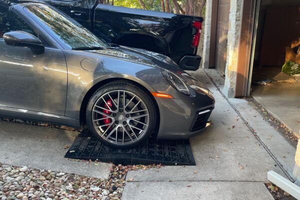 Front Lip Scrape Prevention Ramp System for Steep Driveway Transitions Low sports car using modular rubber ramps to prevent front lip scraping on a steep driveway transition.