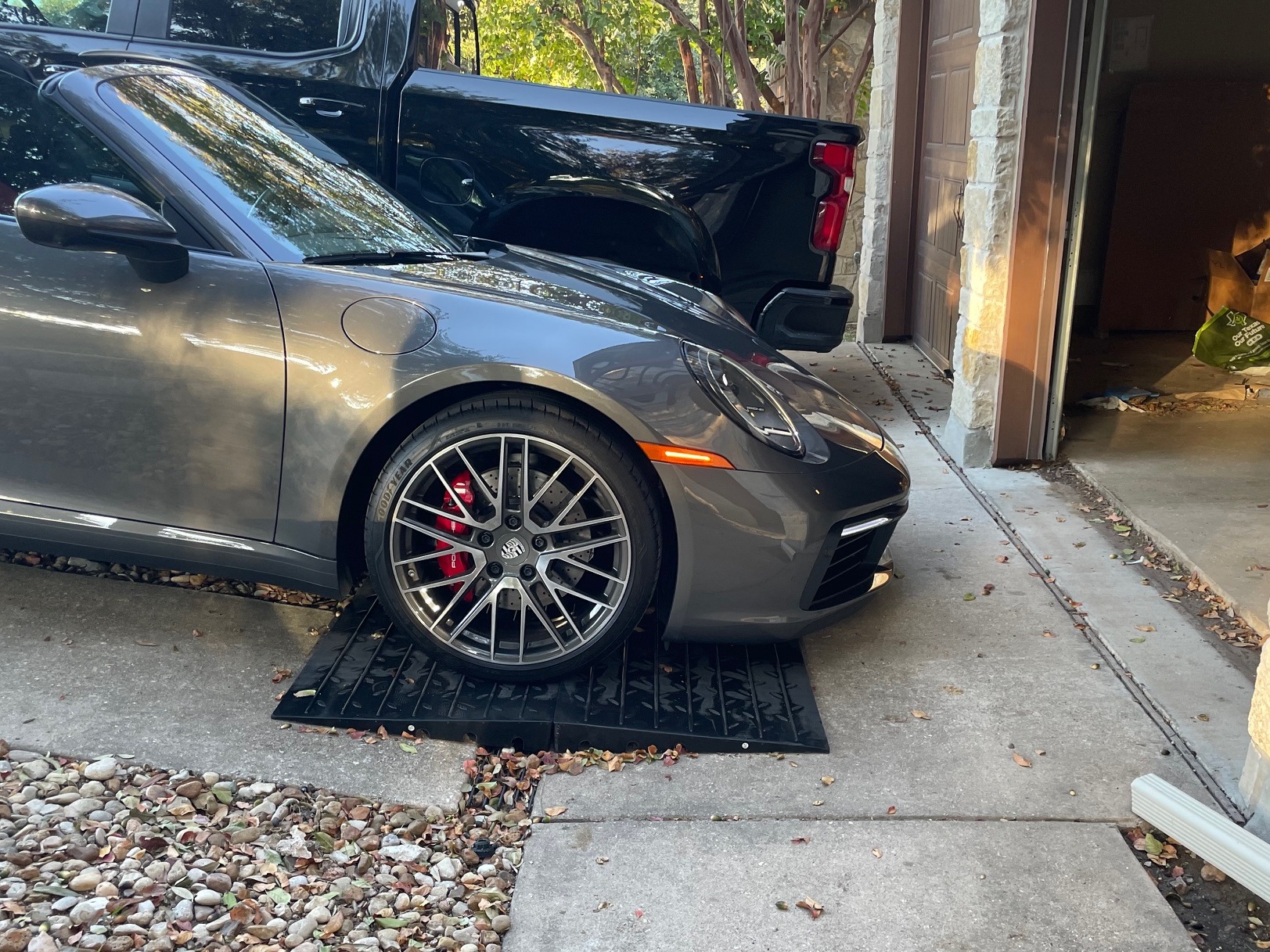 Front Lip Scrape Prevention Ramp System for Steep Driveway Transitions Low sports car using modular rubber ramps to prevent front lip scraping on a steep driveway transition.