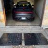 Garage Entry Ramp System for Steep Driveway Lip and Low Car Clearance Low sports car backing into a garage using large rubber entry ramps to smooth out a steep driveway lip.