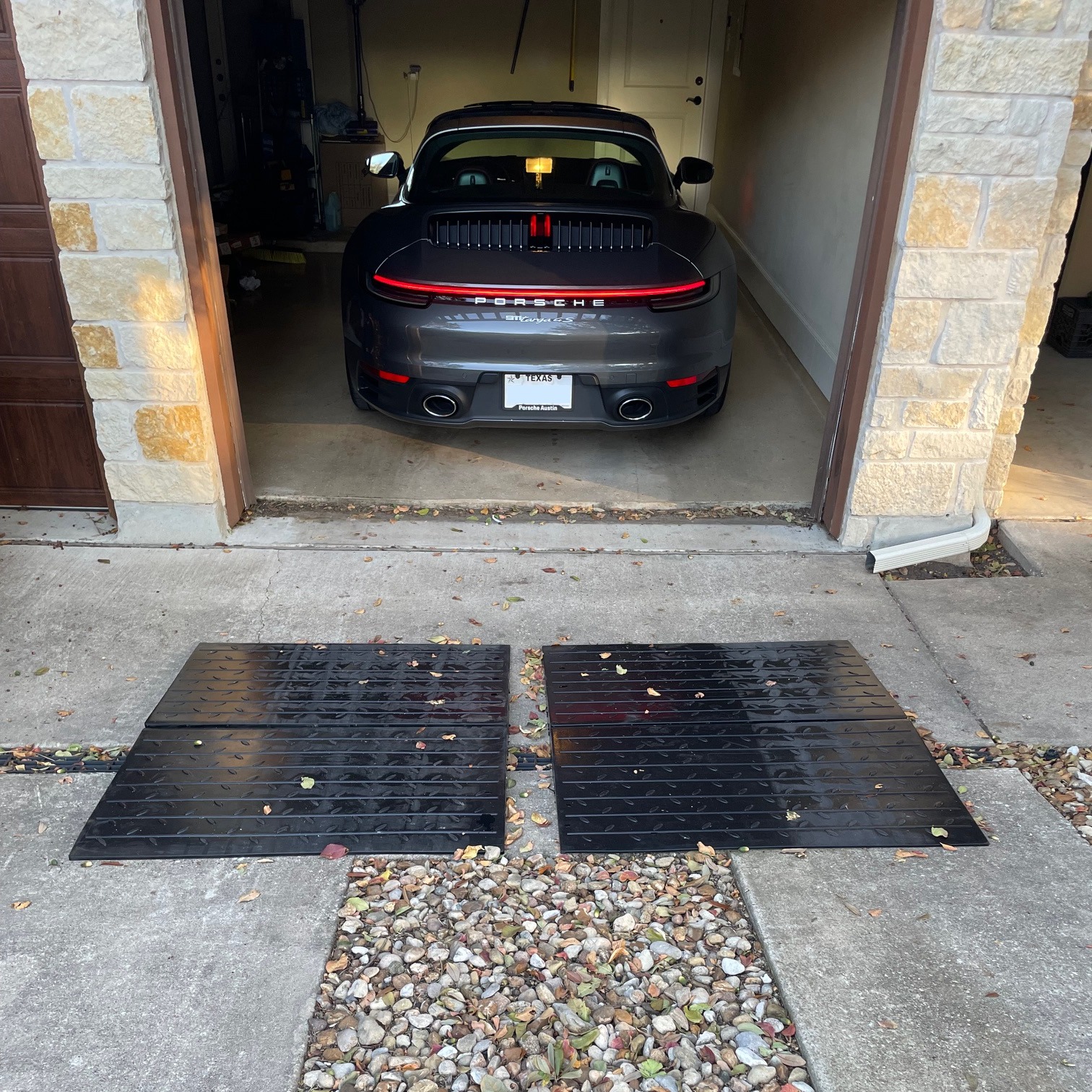 Closeup Garage Threshold Ramp for Low Sports Car Clearance Close-up of a low sports car using modular rubber ramps to climb over a raised garage threshold without scraping.