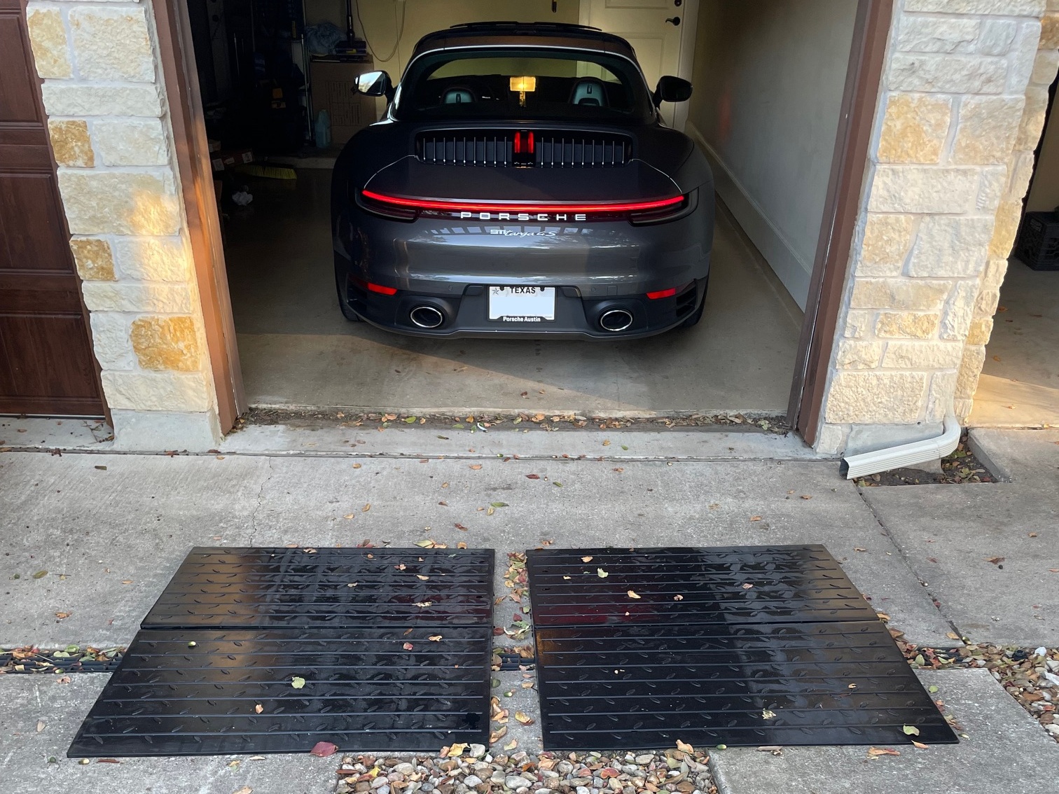 Garage Entry Ramp System for Steep Driveway Lip and Low Car Clearance Low sports car backing into a garage using large rubber entry ramps to smooth out a steep driveway lip.