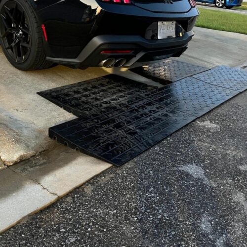 Steep driveway threshold ramp for low car clearance preventing bumper scraping on barrier curb entry