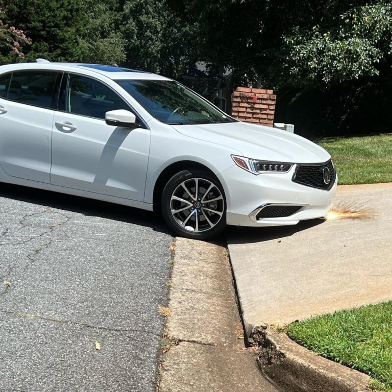 Front bumper scraping on a steep angled driveway lip causing bottoming out and low car clearance issues.