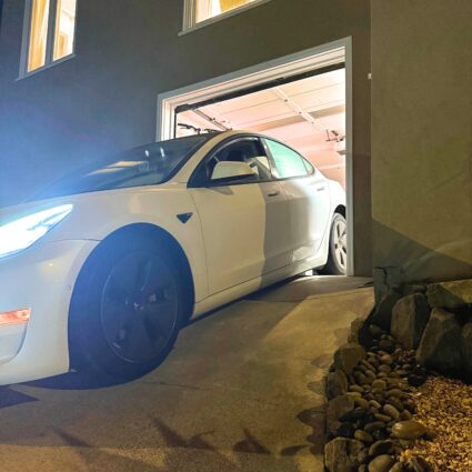 Low-clearance car scraping at a steep garage exit where the driveway angle drops sharply without a curb ramp installed.