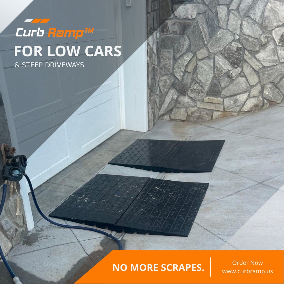 Rubber driveway ramps placed near a garage lip to smooth a steep driveway transition for low-clearance vehicles.