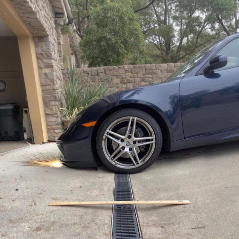 Front bumper scraping on steep garage entry transition over a french drain
